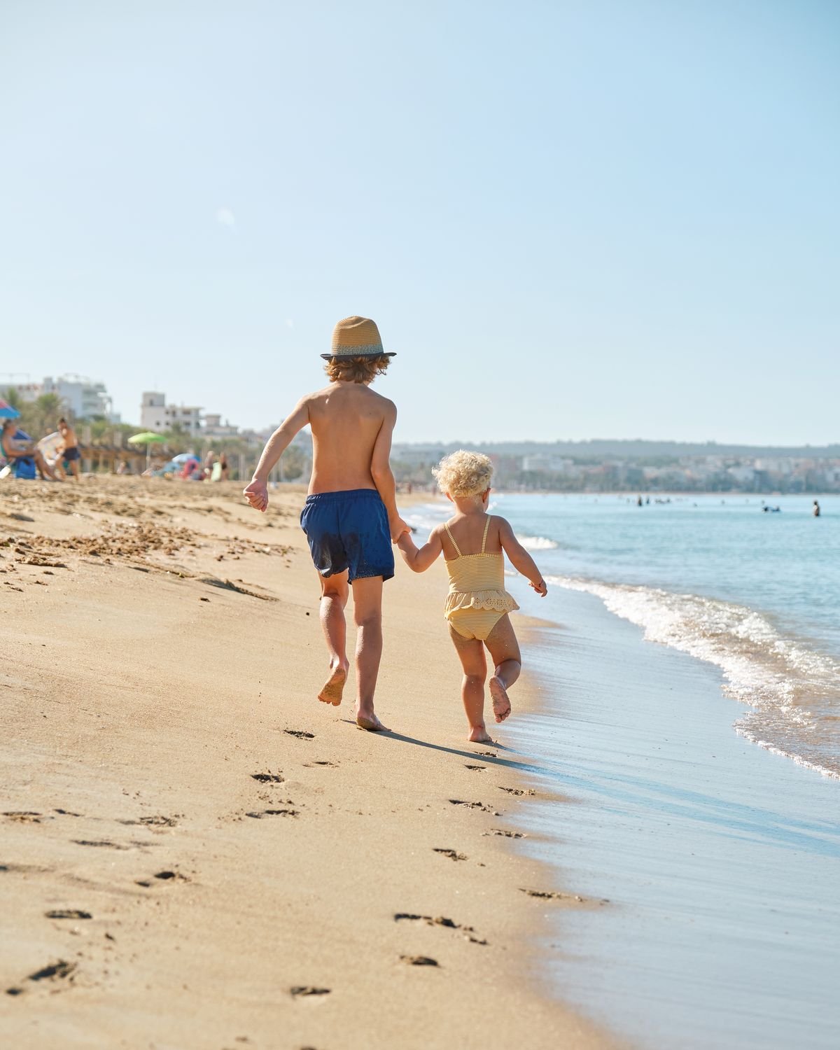 Two children running along the shoreline